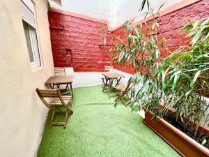 un patio con 2 sillas y césped verde en Cozy guest house next to metro La Salut, en Santa Coloma de Gramenet