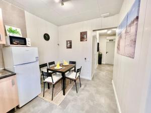 cocina y comedor con mesa y nevera en Cozy guest house next to metro La Salut, en Santa Coloma de Gramenet