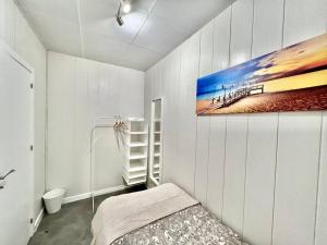 a bedroom with a painting of a pier on the wall at Cozy guest house next to metro La Salut in Santa Coloma de Gramanet