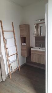 uma casa de banho com uma escada, um lavatório e um espelho. em Le Mas Blanc em Carcassonne