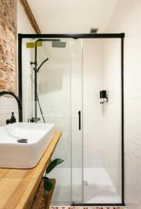 uma casa de banho com um lavatório e uma cabina de duche em vidro. em Good Vibe Rooms em Bilbao