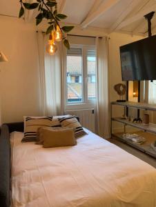 um quarto com uma grande cama branca e uma televisão em Good Vibe Rooms em Bilbao