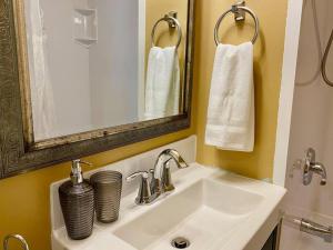 ein Badezimmer mit einem Waschbecken, einem Spiegel und Handtüchern in der Unterkunft Large Townhouse, Lower Floor with AC, City Center in Halifax