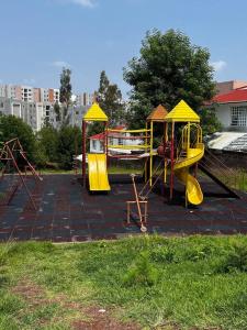 um parque infantil com um escorrega amarelo e uma estrutura de brincar em Casa entera Morelia, hospitales, corporativos 2 em Morelia
