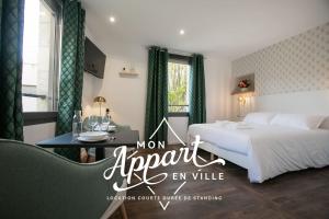 um quarto de hotel com uma cama e uma mesa e uma cama e uma janela em Le Maleville - Balnéo & Ascenseur em Périgueux