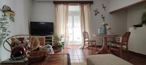 a living room with a television and a table and chairs at El 6 De Busquet in Cáceres