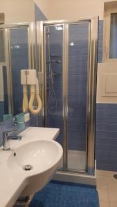 uma casa de banho com um lavatório branco e um chuveiro em R&B Mezzocannone em Nápoles