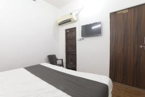 una camera con letto, TV e armadio di Chitraa guest house a Prayagraj