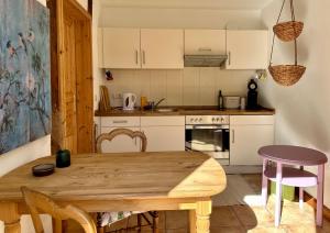 a kitchen with a wooden table and a dining room at Mecklenbü mit Teich, Kamin, Sauna und Hotpott in Dargun