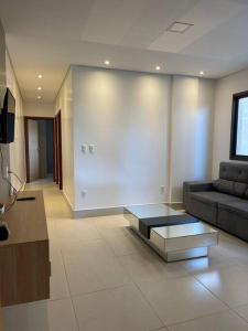 a living room with a couch and a coffee table at Apt climatizado 2 quartos com Wi-Fi! in Patos de Minas