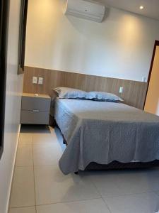 a bedroom with a bed and a nightstand and a bed sidx sidx sidx sidx at Apt climatizado 2 quartos com Wi-Fi! in Patos de Minas
