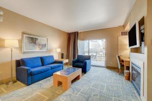 een woonkamer met een blauwe bank en een tv bij Luxury 1BD/1BTH Suite at Platinum Hotel *STRIP VIEW in Las Vegas