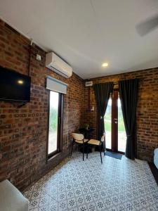 a room with a brick wall and a table and chairs at Sekepeng Penarek II in Kampung Penarik