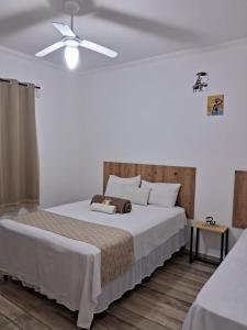 um quarto com uma cama e uma ventoinha de tecto em POUSADA PE NA TERRA EM GUARAREMA em Guararema