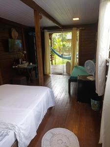 1 dormitorio con 1 cama y puerta corredera de cristal en Suíte Solar en Ilha do Mel