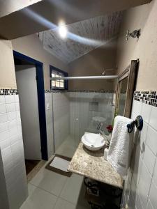 uma casa de banho com um lavatório e um chuveiro em Pousada Flor de Íris em São João del Rei