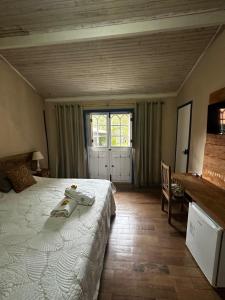 um quarto com uma cama grande e uma janela em Pousada Flor de Íris em São João del Rei