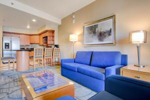 a living room with a blue couch and a kitchen at Luxury 1BD/1BTH Suite at Platinum Hotel *STRIP VIEW in Las Vegas