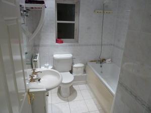 a bathroom with a toilet and a sink and a tub at Spacious in Croxley Green +4 photos