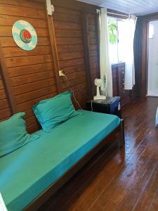 1 dormitorio con 1 cama con pared de madera en Suíte Solar en Ilha do Mel