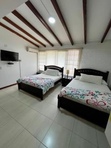 a bedroom with two beds and a flat screen tv at CasaBlanca Boutique in Cali