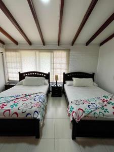 two beds sitting next to each other in a bedroom at CasaBlanca Boutique in Cali