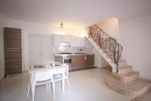 a kitchen with a staircase with a table and chairs at Giù nei Sassi in Matera