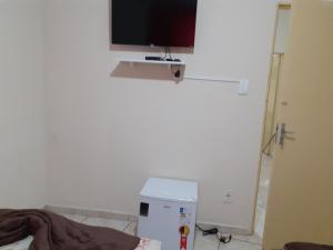 a living room with a tv on a wall at Espaço matteo in Aparecida