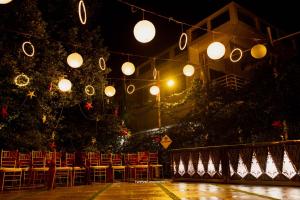 un groupe de chaises assises sous une bande de lumières dans l'établissement Kayyalas Courtyard, à Thrissur