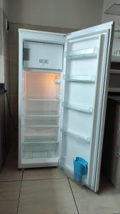 an empty refrigerator with its door open in a kitchen at Sopocachi BnB - Chic Apartment in La Paz