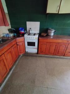 eine Küche mit einem Herd und einigen Holzschränken in der Unterkunft Pecas house in Mina Clavero