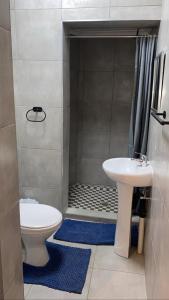 a bathroom with a toilet and a sink and a shower at OR Tambo Stay Unit 2 in Boksburg
