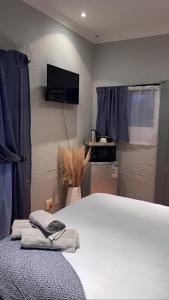a bedroom with a bed and a tv on the wall at OR Tambo Stay Unit 2 in Boksburg