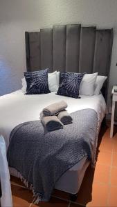 a bedroom with a large bed with blue and white pillows at OR Tambo Stay Unit 2 in Boksburg