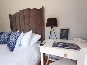 a bedroom with a bed with a desk with a lamp at OR Tambo Stay Unit 2 in Boksburg