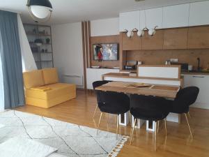 a kitchen and dining room with a table and chairs at Bjelasnica Loft Apartment in Bjelašnica