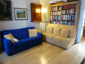 ein Wohnzimmer mit einem Sofa und einem Bücherregal mit Büchern in der Unterkunft Spacious in Croxley Green