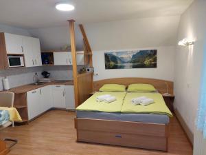 a small bedroom with a bed and a kitchen at Apartmaji Vesna in Bohinj
