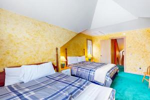 2 camas en una habitación con paredes amarillas en The Pond House, en Dover