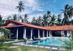 a house with a swimming pool in front of it at Villa Blue Lotus Katunayake in Katunayake