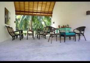 grupa krzeseł i stołów w pokoju w obiekcie Villa Blue Lotus Katunayake w mieście Katunayake