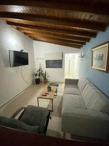 a living room with a couch and a tv at Apartamento cómodo y agradable in Medellín