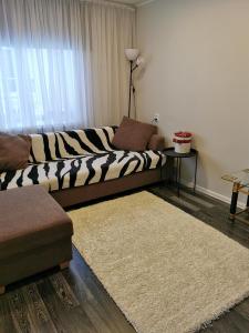 ein Wohnzimmer mit einem Zebra-Sofa und einem Teppich in der Unterkunft Jaama Apartement in Valga
