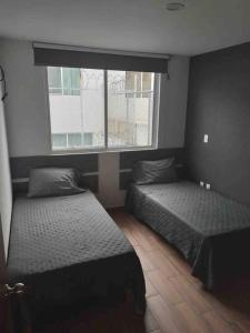 1 dormitorio con 2 camas y ventana en Casa entera Morelia, hospitales, corporativos 1, en Atapaneo