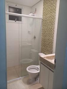 uma casa de banho com um WC e uma cabina de duche em vidro. em Apt aconchegante com 2 quartos! j em Patos de Minas