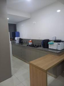 eine Küche mit Theke und Mikrowelle in der Unterkunft Apt aconchegante com 2 quartos! j in Patos de Minas
