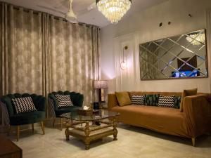 a living room with a couch and chairs and a table at Homey Stays - 3 Bedroom Holiday Home - DHA in Lahore