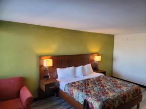 a hotel room with a bed and a chair at Jackson Hotel & Convention Center in Jackson