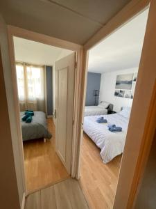 - une petite chambre avec 2 lits et un miroir dans l'établissement magnifique Duplex avec 2 chambres et parking gratuit, à Grenoble