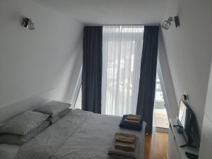 a bedroom with a bed and a large window at Bjelasnica Loft Apartment in Bjelašnica